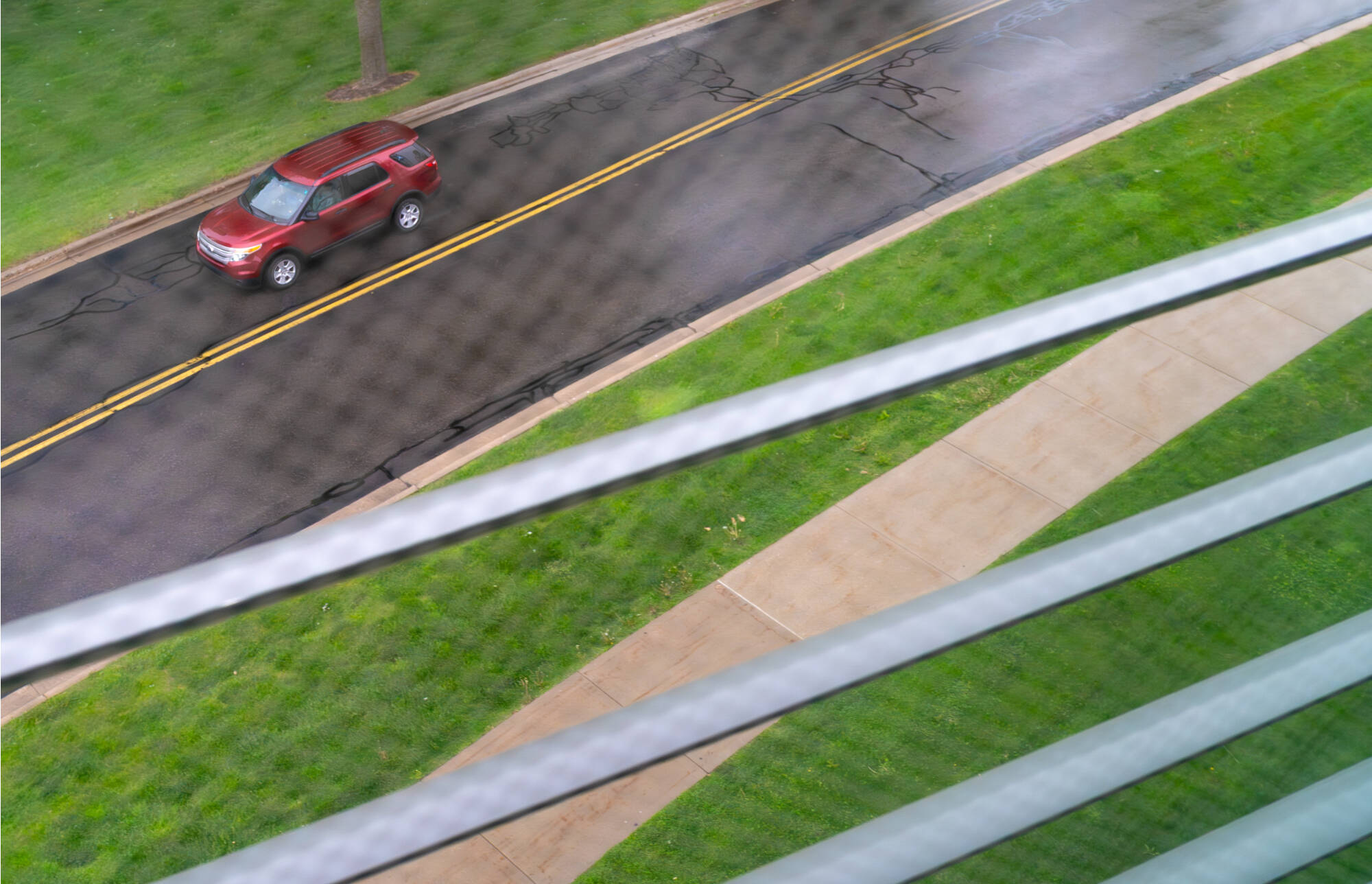 A vehicle travels along South Campus Drive, as pictured through a window of the Mary Idema Pew Library, on May 20.